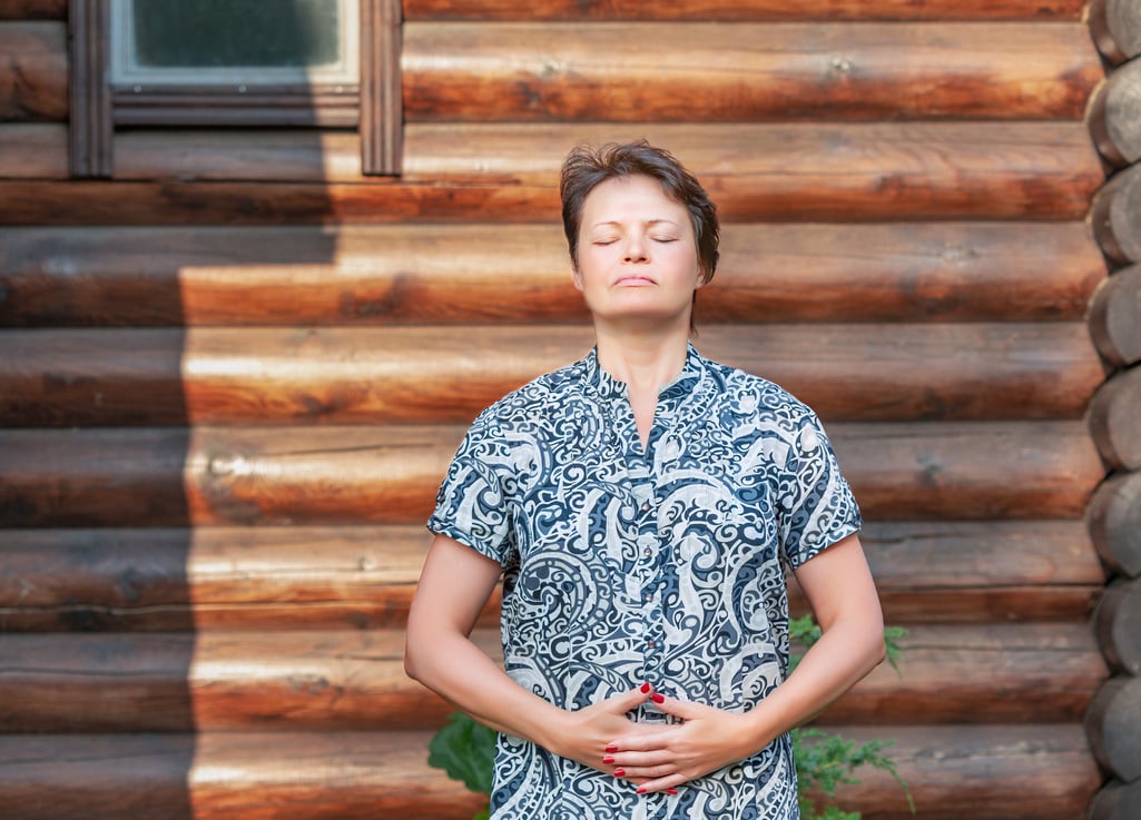 An adult woman practicing Qigong breathing exercises